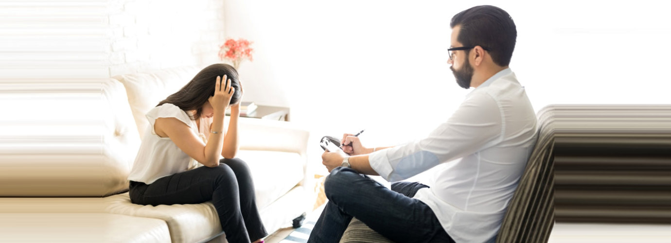 woman sitting on the sofa counseling by the professional counselor wearing eyeglasses